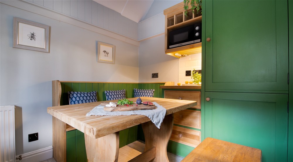 The dining area with bench seating at Hardcastle Lodge in Hebden Bridge, West Yorkshire