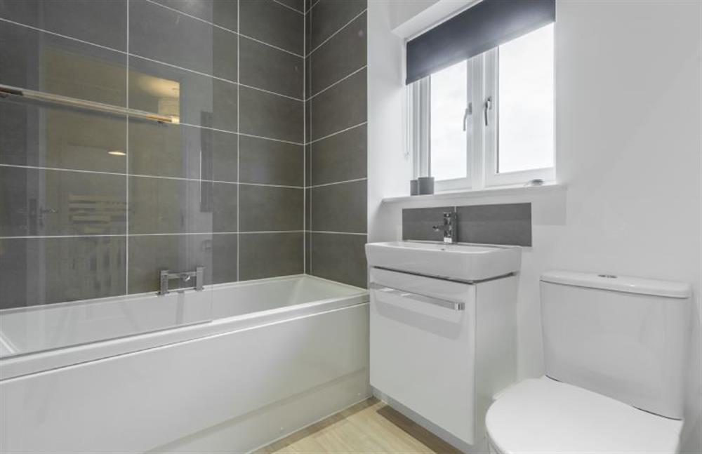 First floor: Family bathroom with bath with shower over at Hare Cottage, Bodham near Holt