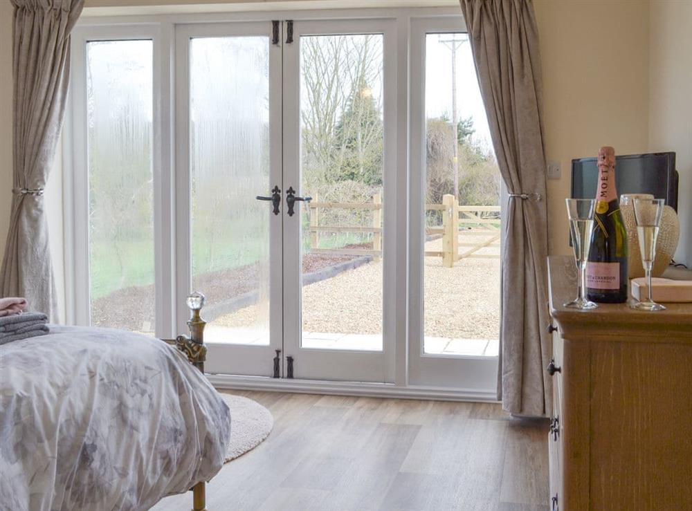 Peaceful double bedroom with French doors to second patio area at Hares Home in Thursford, near Fakenham, Norfolk