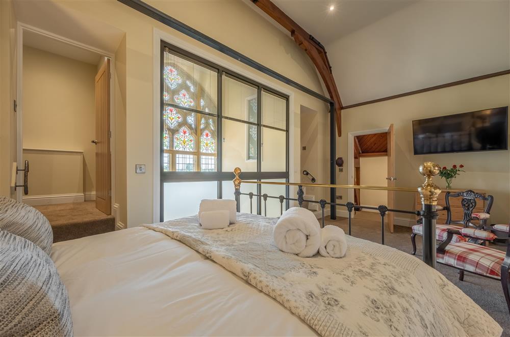 First floor: Master bedroom featuring king-size bed and walk-in wardrobe at Harome Chapel, Harome, near Helmsley 