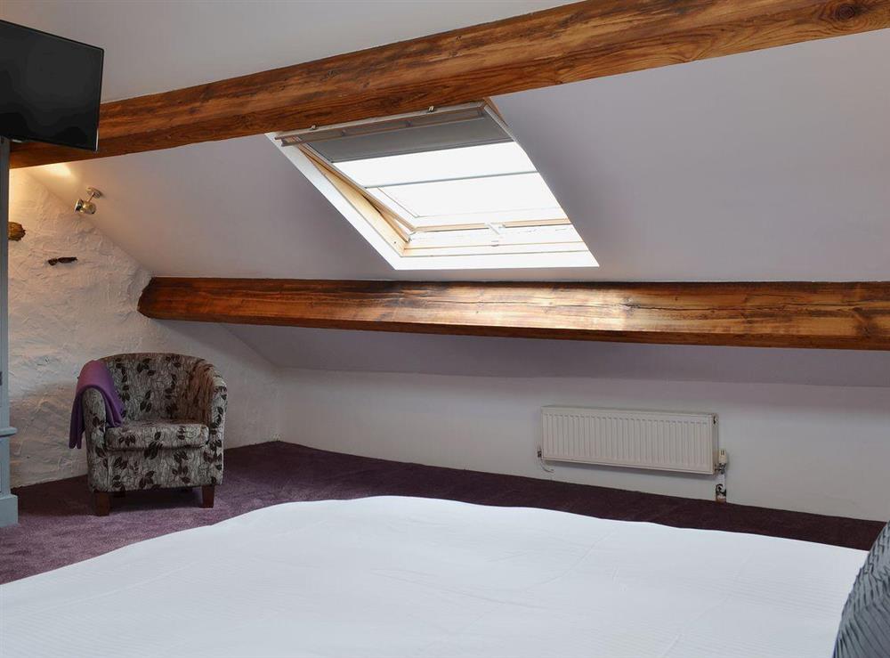 Double bedroom in loft space with Velux window and exposed beams at Havelock Cottage in Windermere, Cumbria