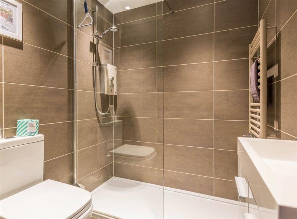 En suite shower room with floor to celing tiles at Havelock Cottage in Windermere, Cumbria