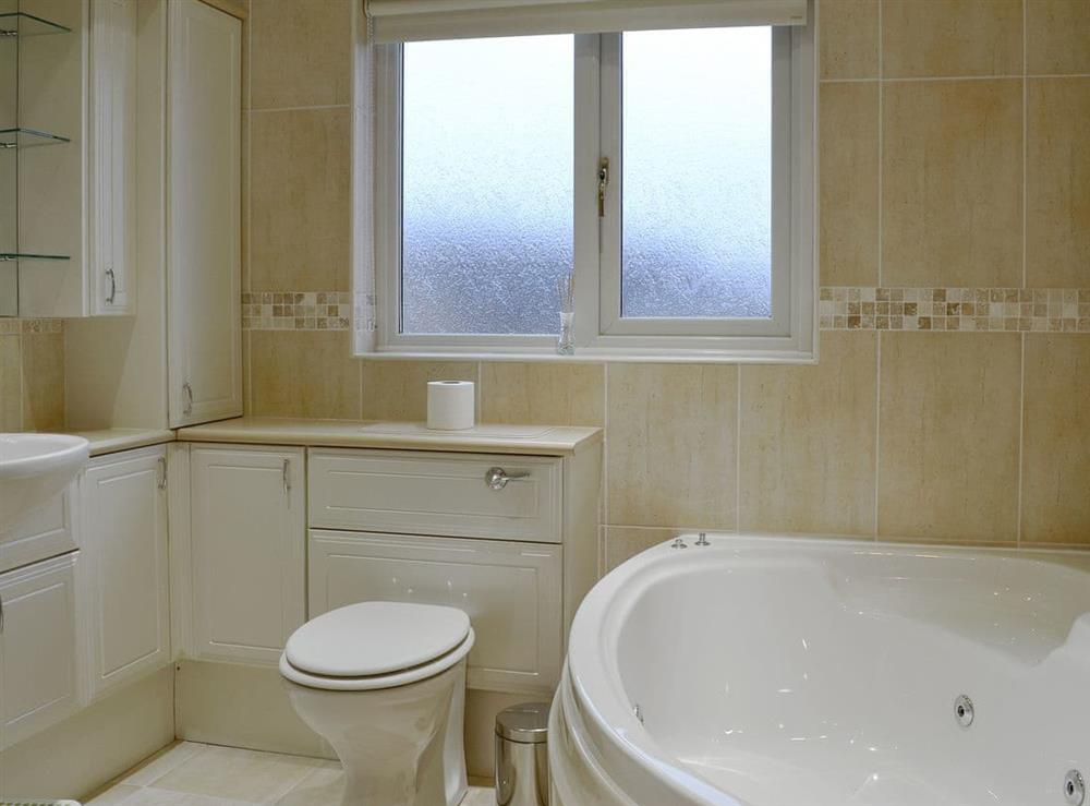 Bathroom with spa bath and shower cubicle at Hawthorn Cottage in Stranraer, Wigtownshire