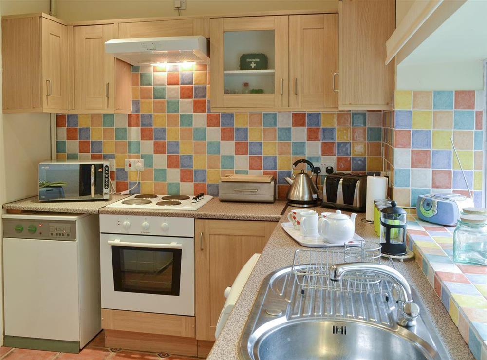 Well-equipped kitchen with tiled splashback at Hay Cottage in St Austell, S. Cornwall., Great Britain