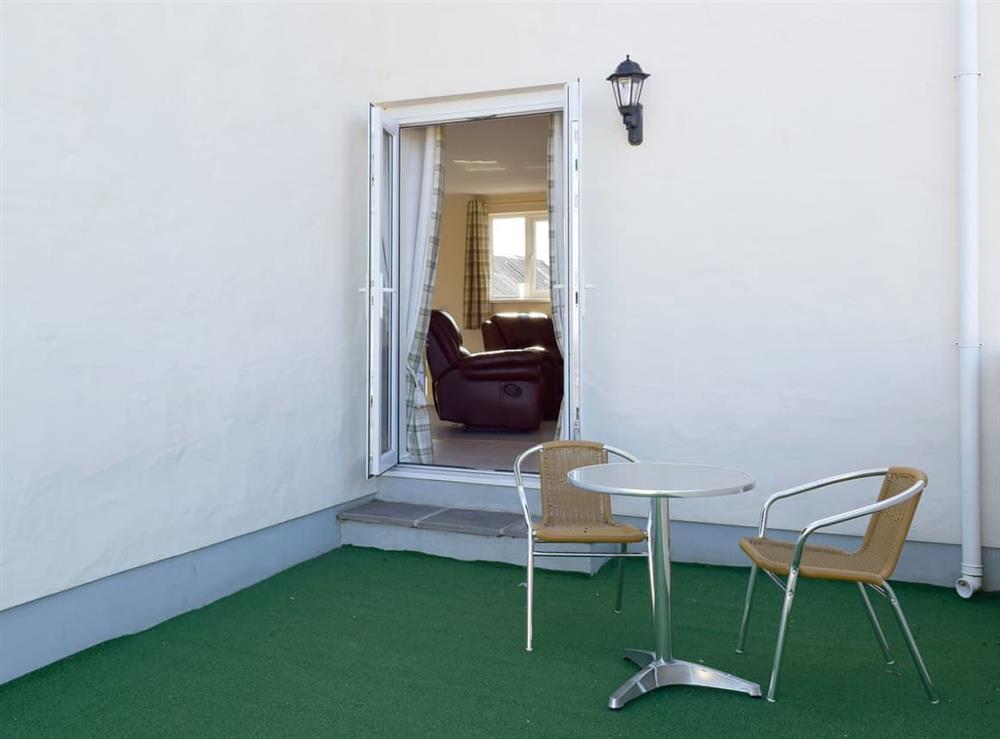 Enclosed courtyard with sitting-out area and garden furniture at Stable Cottage, 