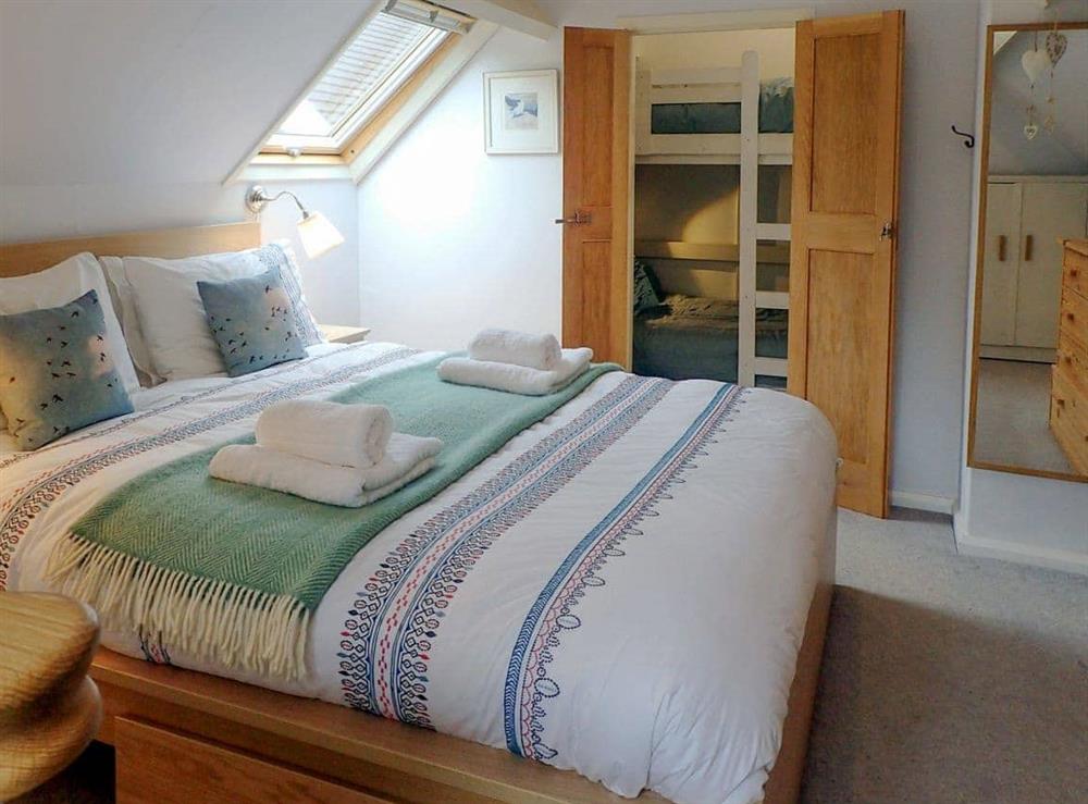 Double bedroom leading through to bunk bedroom at Heale Cottage in Littleham, near Bideford, Devon