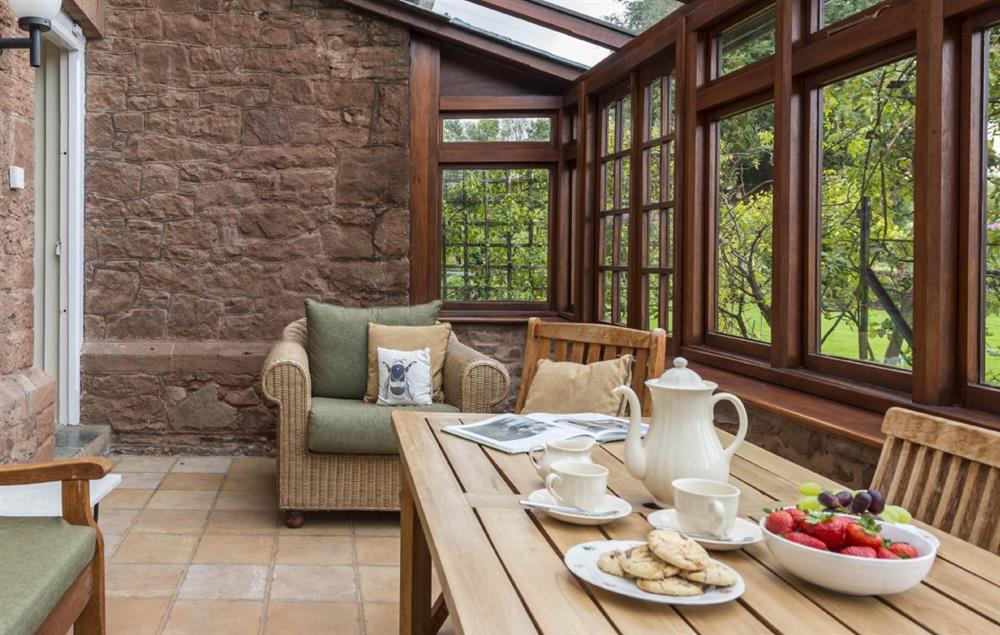 South facing conservatory with table seating six guests and doors to the garden (photo 2) at Hearn Lodge, Bishops Lydeard