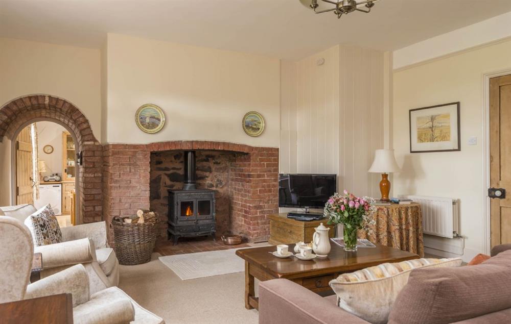 Spacious sitting room with wood burning stove and dining table at Hearn Lodge, Bishops Lydeard