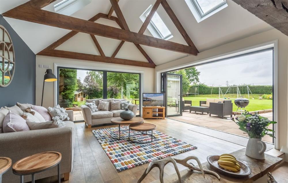 The spacious sofa room with stunning bi-fold doors out to the garden at Heath Cottage, Mattishall