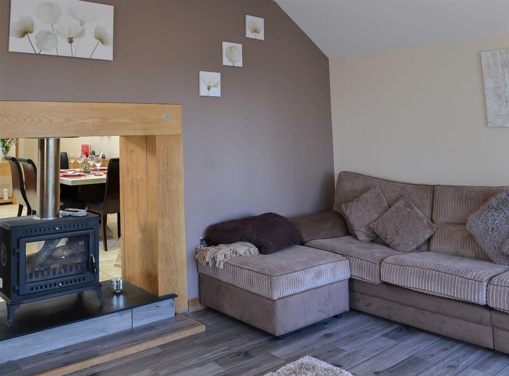 Cosy and comfortable living room with dual aspect wood burner at Heckley Stable Cottage, 