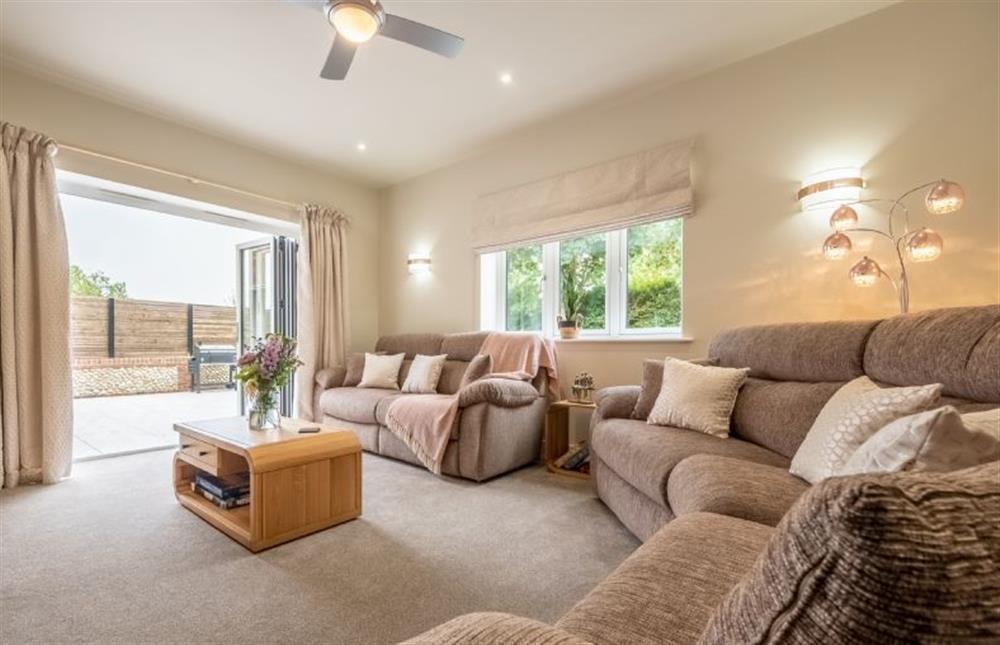 Bi-fold doors in the sitting room open to the garden at Hedgerows, Burnham Market near Kings Lynn