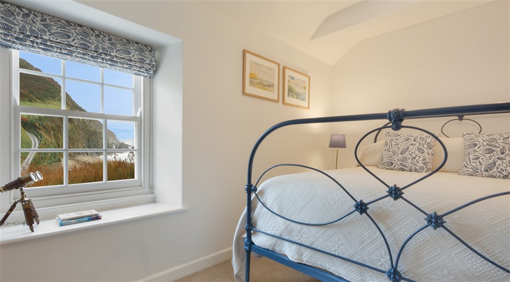 The double bedroom has views over the beach at Hemmick Cottage in Cornwall,