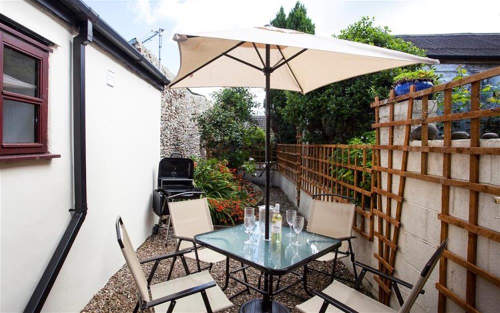 The private outdoor patio area provides a table, seating and a bbq