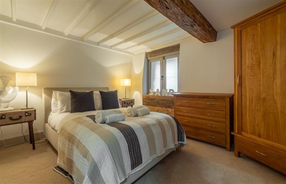 First floor: Bedroom three, double bed and beamed ceiling at Hideaway Barn, Thornham near Hunstanton