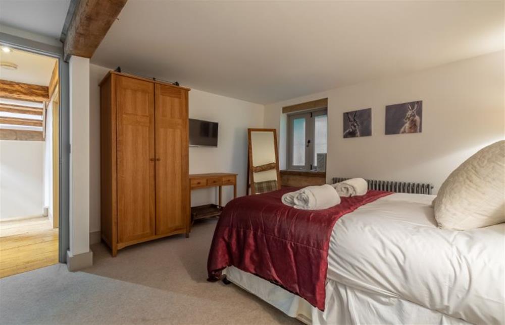 First floor: Bedroom two, King-size bedroom has en-suite bathroom at Hideaway Barn, Thornham near Hunstanton