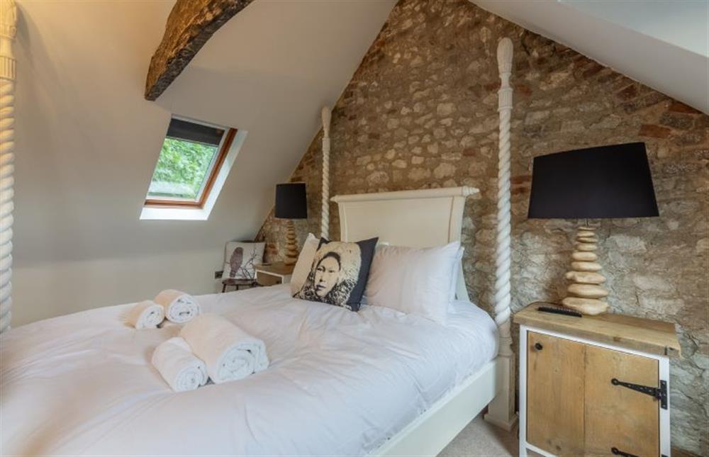 Second floor: Master bedroom has king-size four poster bed at Hideaway Barn, Thornham near Hunstanton