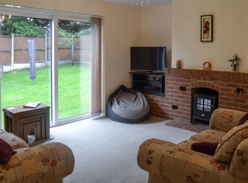 Living room with sliding patio doors leading to garden at Hideaway Cottage in Kingsgate, near Broadstairs, Kent