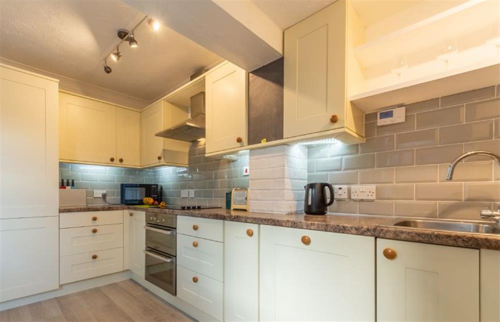 Kitchen area with electric cooker, fridge/freezer, microwave and dishwasher at Hideaway Cottage, Leiston