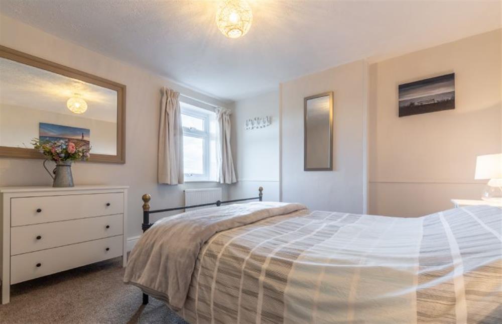 Master bedroom with a king-size bed at Hideaway Cottage, Leiston