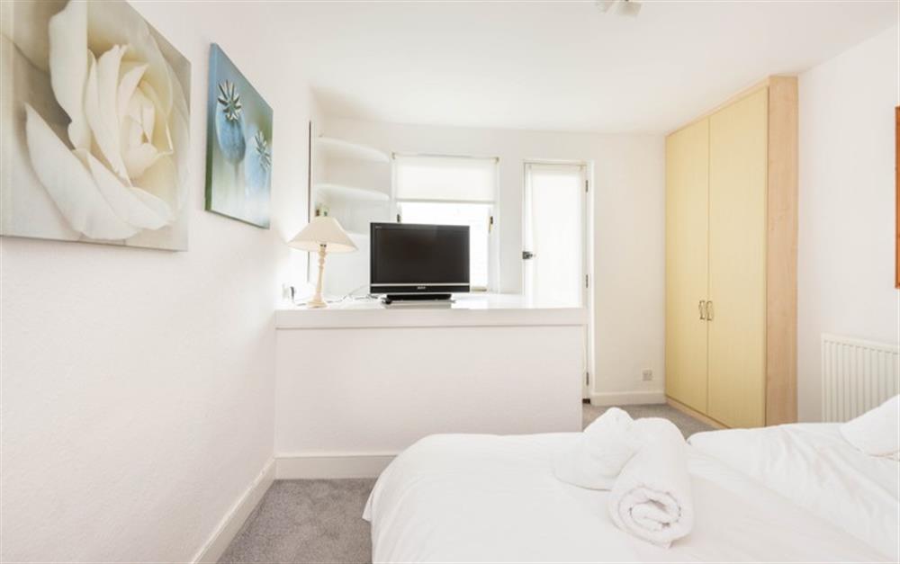 Twin room with large wardrobe and TV. at Hideaway in Salcombe