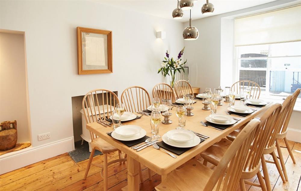 The dining room with a gas wood burning stove effect fire at High House (Sleeping 10), Tenby