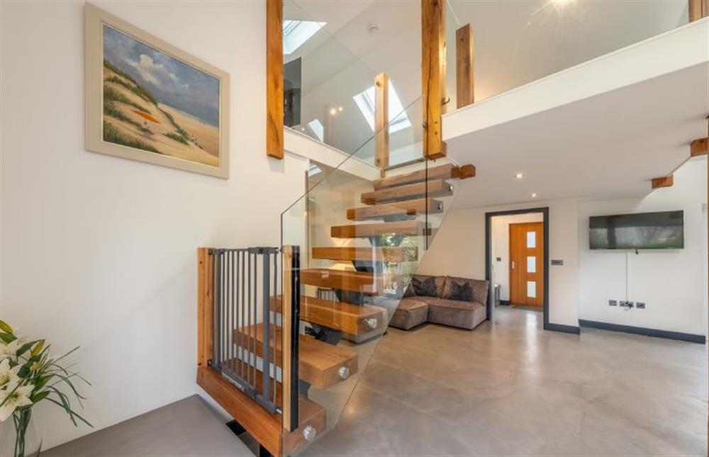 Floating wooden staircase with glass balustrade to first floor