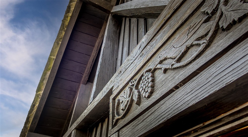 Strawberry plant design carved into the wood of the exterior of the first floor of High Strawberry Gardens, Cumbria at High Strawberry Gardens in Near Hawkshead, Cumbria