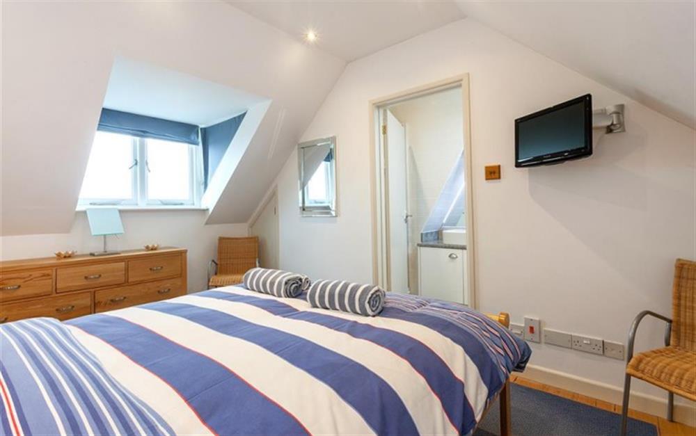 Bedroom 3. The attic room with king size bed, TV and en suite shower room at High Tor in Salcombe