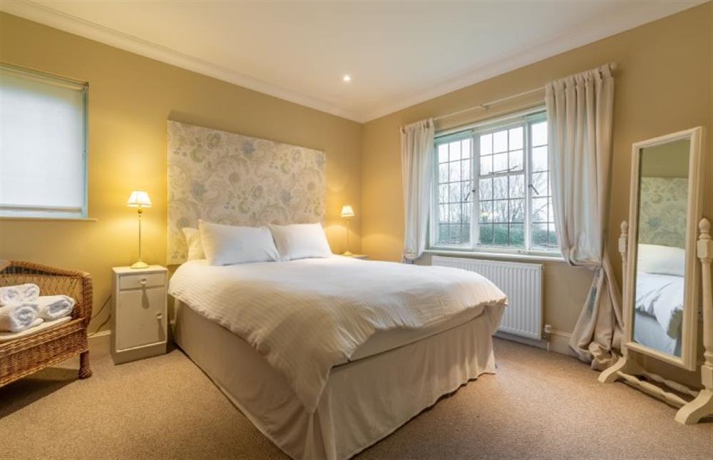 Bedroom with king-size bed and views out onto garden and parkland beyond at Higham Place Lodge, Higham