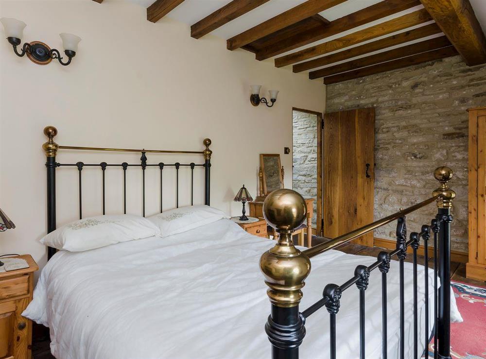 Traditional double bed room beamed ceiling and wooden floors at Highbury Cottage in Hathersage, South Yorkshire