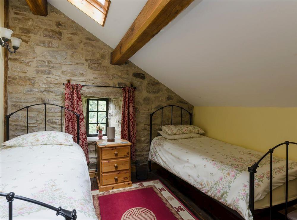 Traditional twin bed room beamed ceiling and wooden floors at Highbury Cottage in Hathersage, South Yorkshire
