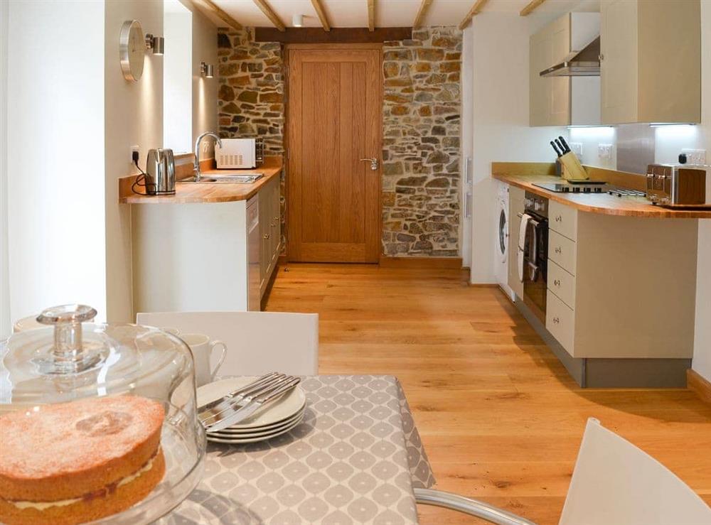 Charming dining area and adjacent kitchen at The Oak Stall, 