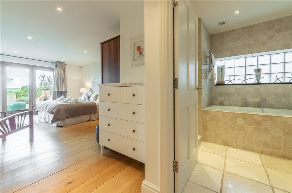 Bedroom with 5’ king-size bed, en-suite bathroom and bi-fold doors to the terrace (photo 3) at Higher Close, Mawgan Porth