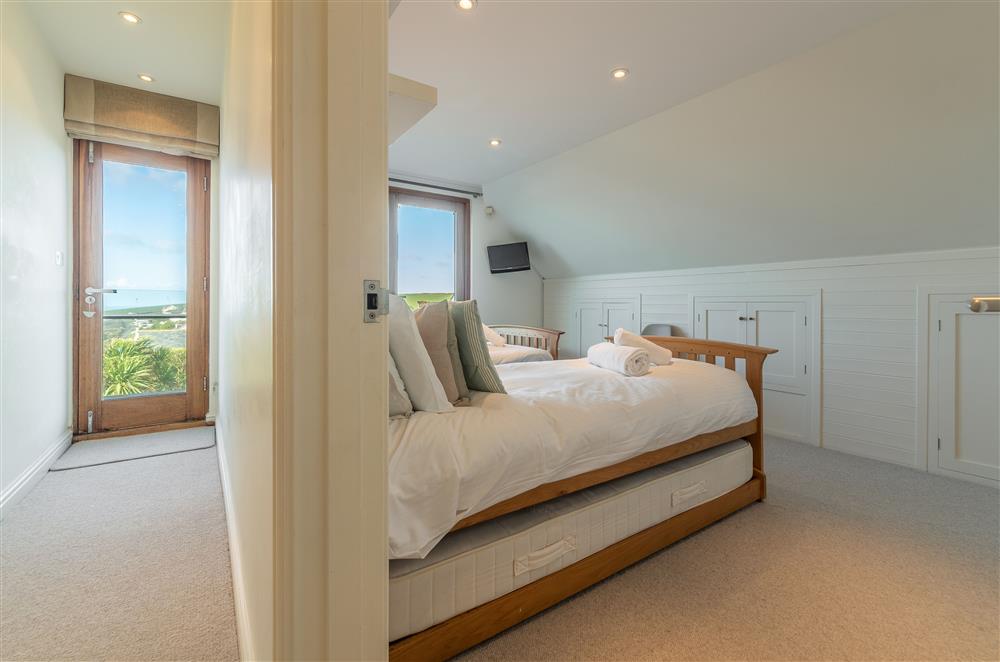 Bedroom with twin single beds, balcony and en-suite shower room at Higher Close, Mawgan Porth