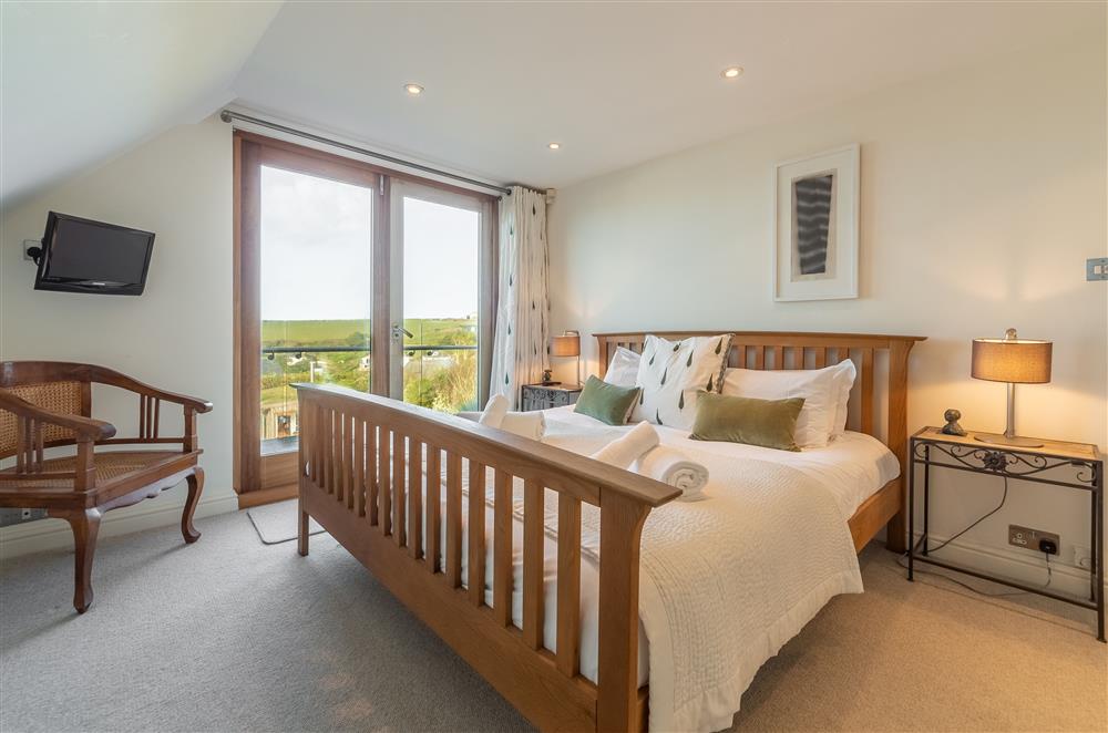 Master bedroom with 5’ king-size bed, en-suite shower room and balcony at Higher Close, Mawgan Porth