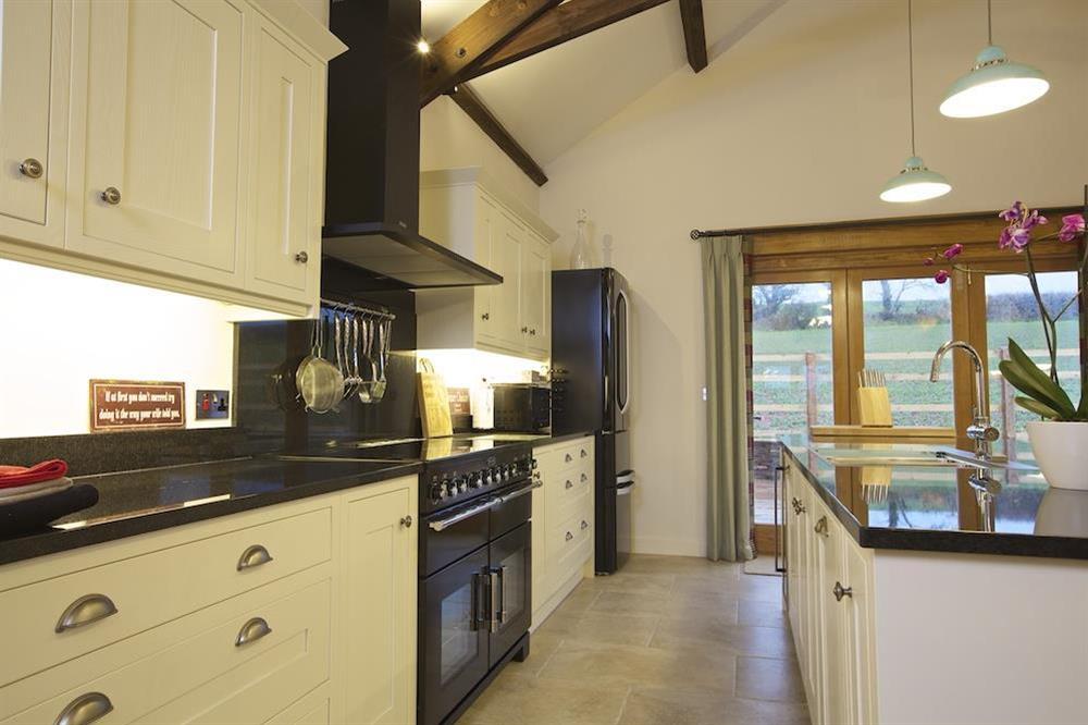 Contemporary kitchen with cream units and black granite worktops and Rangemaster cooker at Higher Hill Barn in , Nr Kingsbridge