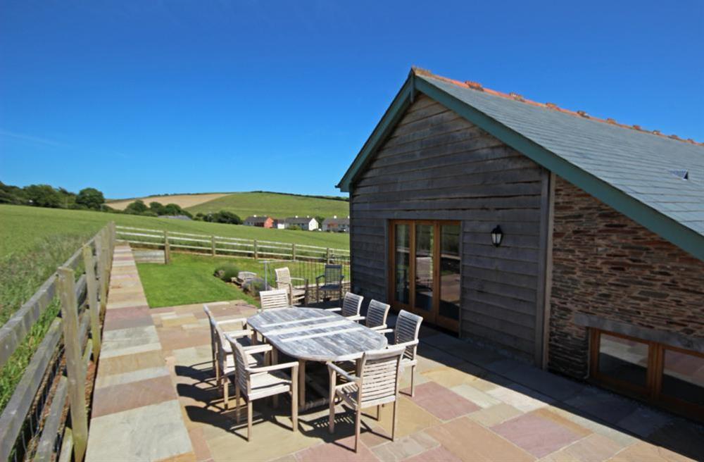Large terrace with garden table chairs and built-in barbecue at Higher Hill Barn in , Nr Kingsbridge