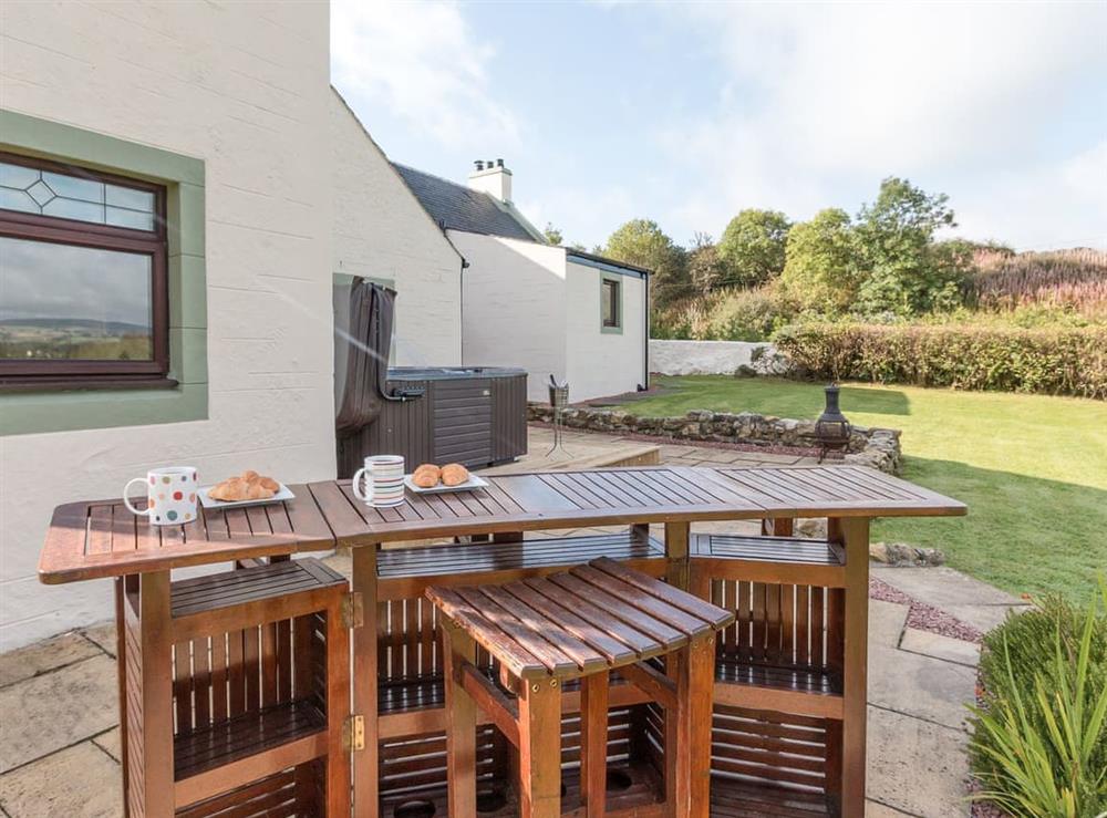 Lawned garden with sitting-out area, garden furniture and hot tub at Hill End Farmhouse in Dalry, Ayrshire