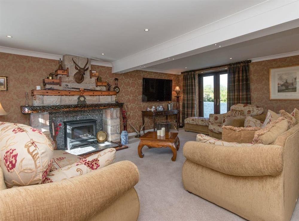 Living room with French doors leading to the garden at Hill End Farmhouse in Dalry, Ayrshire