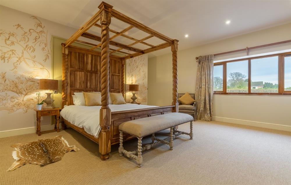 Master bedroom with 6’ super king-size four poster bed with views into the deer park. at Hill Farm Massingham, Little Massingham