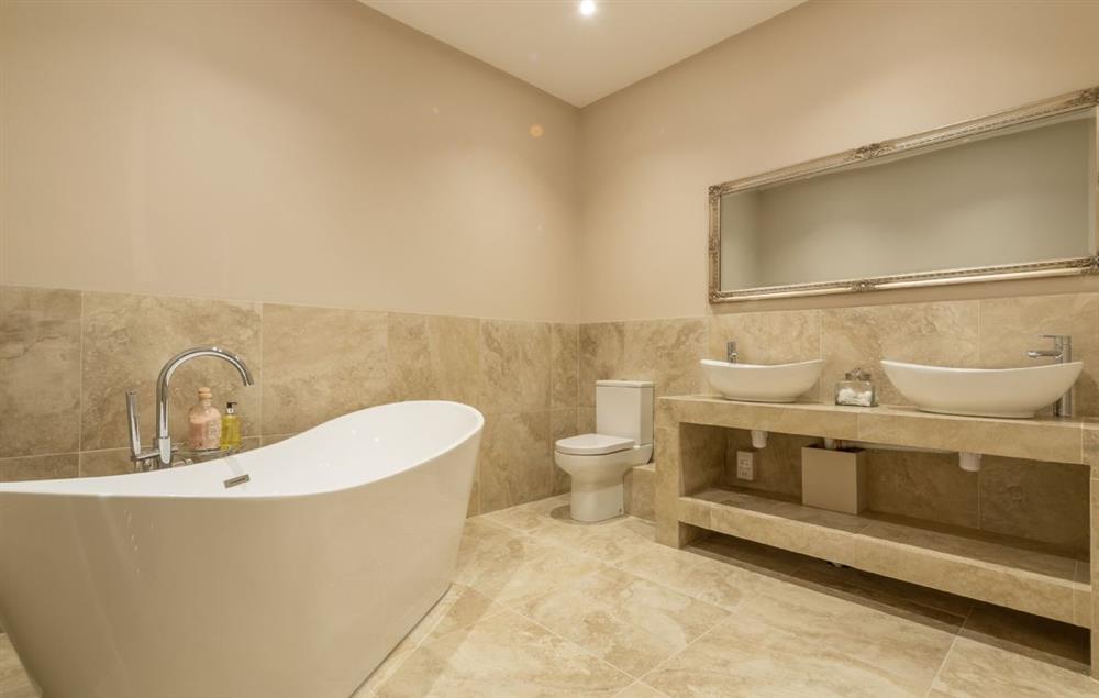 Master en-suite with double ended slipper bath, luxury shower, double basins, WC and heated hand rail
