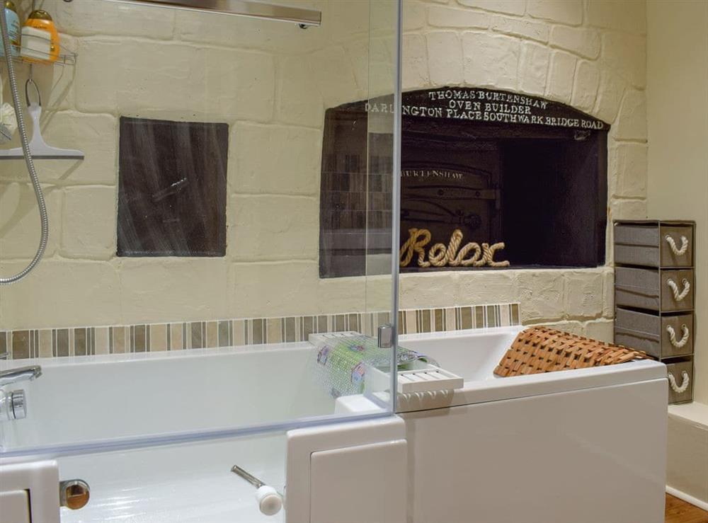 Characterful bathroom with shower over a walk-in P-shaped bath at Hill House Bakery in Ventnor, Isle of Wight