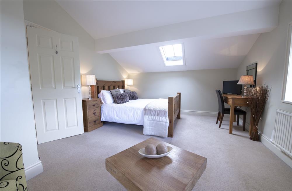 Bedroom five with a 4’6 double bed, seating area and television; and en-suite shower room at Hill Top Farm, Askrigg, Nr Leyburn