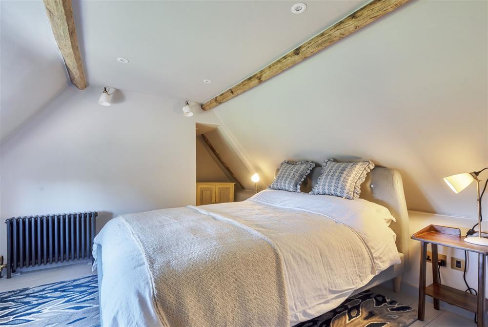 Bedroom one with a 5’ king-size bed at Hilltop Cottage, Wimborne