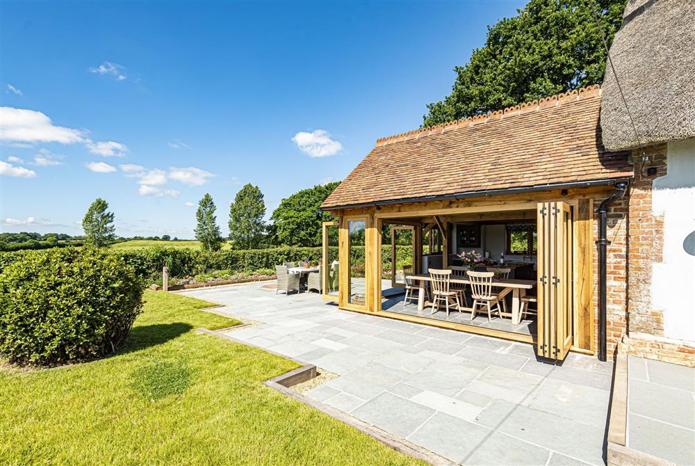 The open-plan kitchen and dining area with the bi-folding doors open at Hilltop Cottage, Wimborne