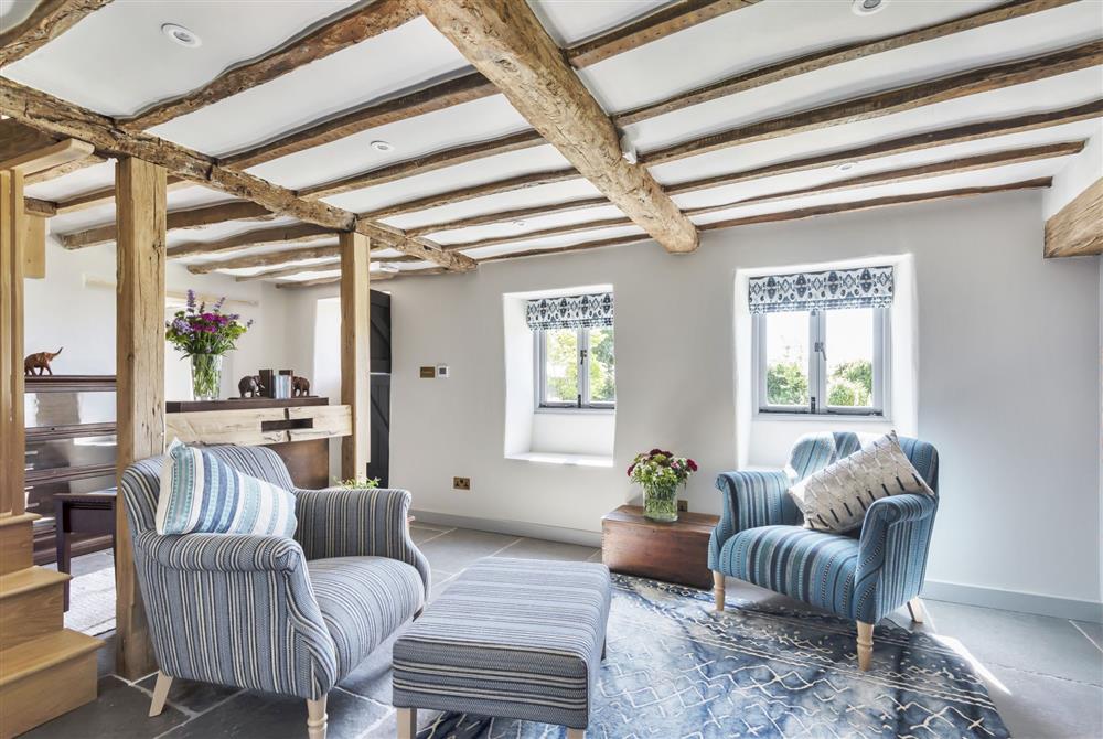 The sitting room connects directly with the snug with a partially open-plan layout at Hilltop Cottage, Wimborne