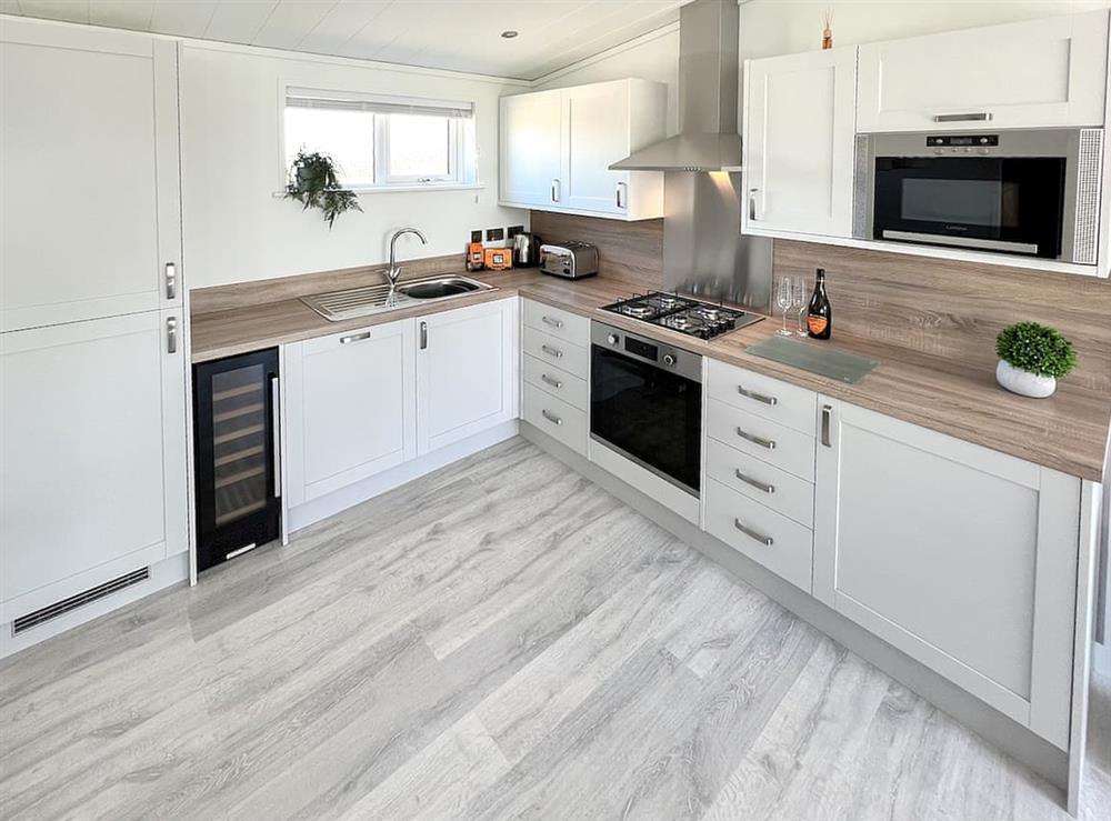 Kitchen with full-size fridge freezer, wine chiller, dishwasher, oven, microwave, and toaster. Fully equipped with crockery and cutlery at Hoburne in Bodmin, Cornwall