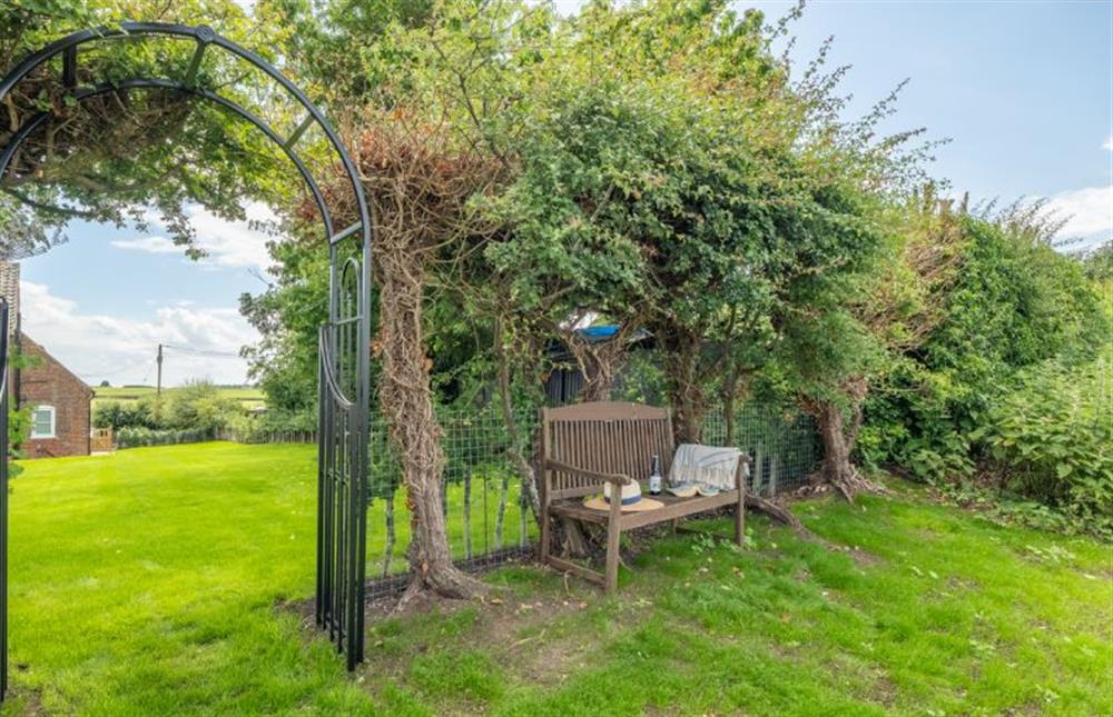 At the bottom of the garden is a gate with a bench where you can enjoy the rural views at Holkham Skies, Wells-next-the-Sea