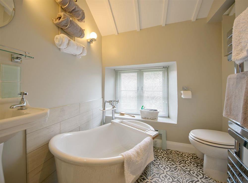 Bathroom with roll-top bath & shower at Holliers Cottage in Middle Barton, near Chipping Norton, Oxfordshire