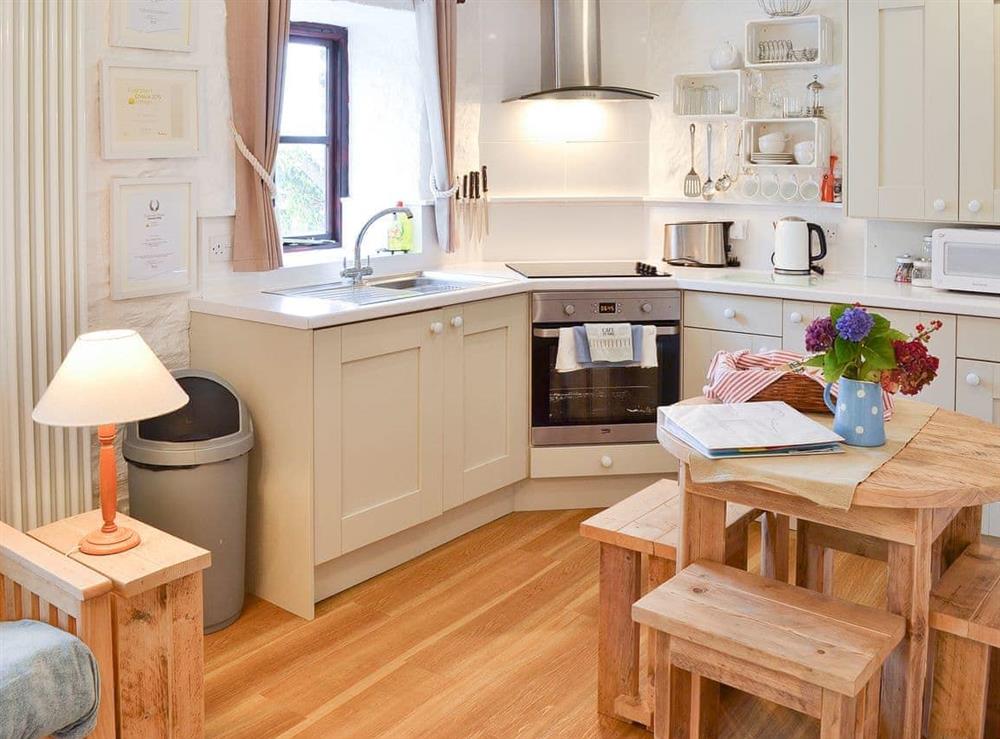 Well-equipped fitted kitchen with convenient dining area at Hollies Cottage in Goonhavern, near Perranporth, Cornwall
